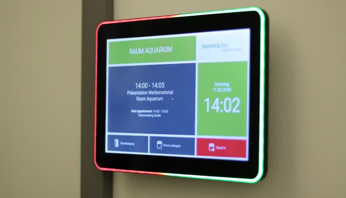 Digitales Türschild mit LED-Farbanzeige zur Anzeige der aktuellen Raumbelegung und verbleibenden Meeting-Dauer. Das Display zeigt eine Raumreservierung für „Raum Aquarium“ mit einer Uhrzeit- und Terminübersicht.