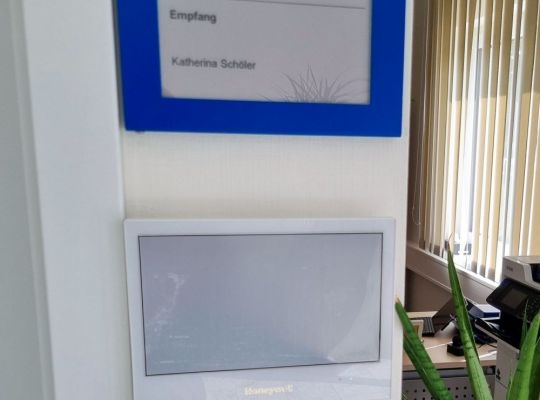 Monochromes digitales Türschild zeigt den Namen des zuständigen Ansprechpartners im Empfangsbereich von EFEN an.