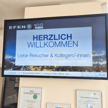 EFEN Begrüßungsmonitor zeigt Willkommensnachricht für Besucher im Empfangsbereich.
