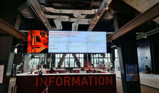 Ein Empfangsmonitor begrüßt und informiert Besucher in einer Ausstellung