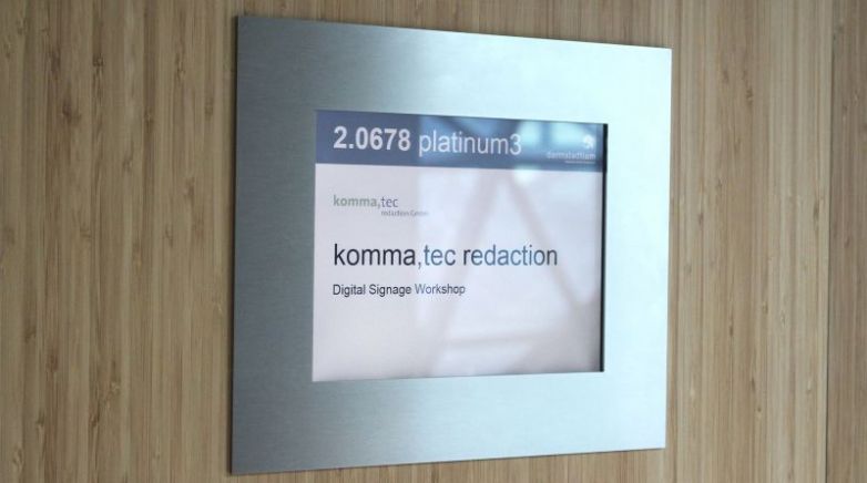Digitales Türschild zeigt Raumbezeichnung und Veranstaltungsdetails für einen Digital Signage Workshop der komma,tec redaction.