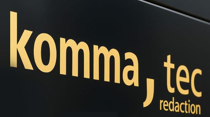 Das Bild zeigt ein Schild des Unternehmens " komma,tec redaction"
