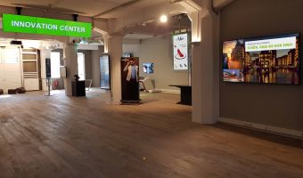 Innenansicht des Innovation Centers der komma,tec redaction, das moderne Digital Signage Displays und innovative Technologie-Lösungen in einer großzügigen Ausstellungsfläche präsentiert.