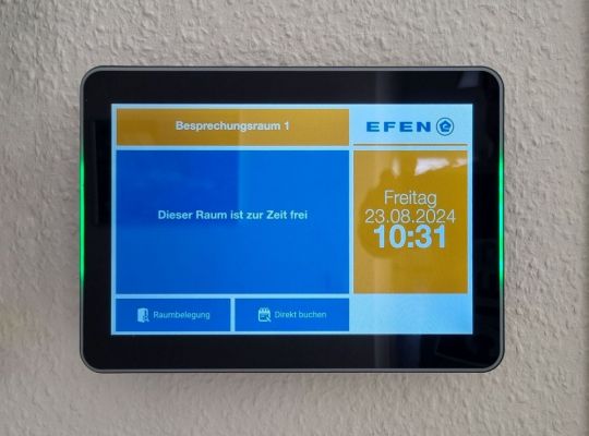 Digitales Türschild zeigt Verfügbarkeit von Besprechungsräumen und Buchungsoptionen bei EFEN.