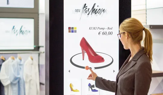 Ein digitales Werbedisplay zeigt neue Schuhmodelle