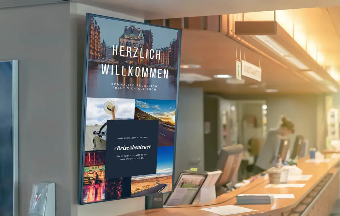 Digitales Display in einer Empfangshalle mit der Aufschrift "Herzlich Willkommen" und verschiedenen Reisebildern, das zur Teilnahme an #ReiseAbenteuer einlädt.