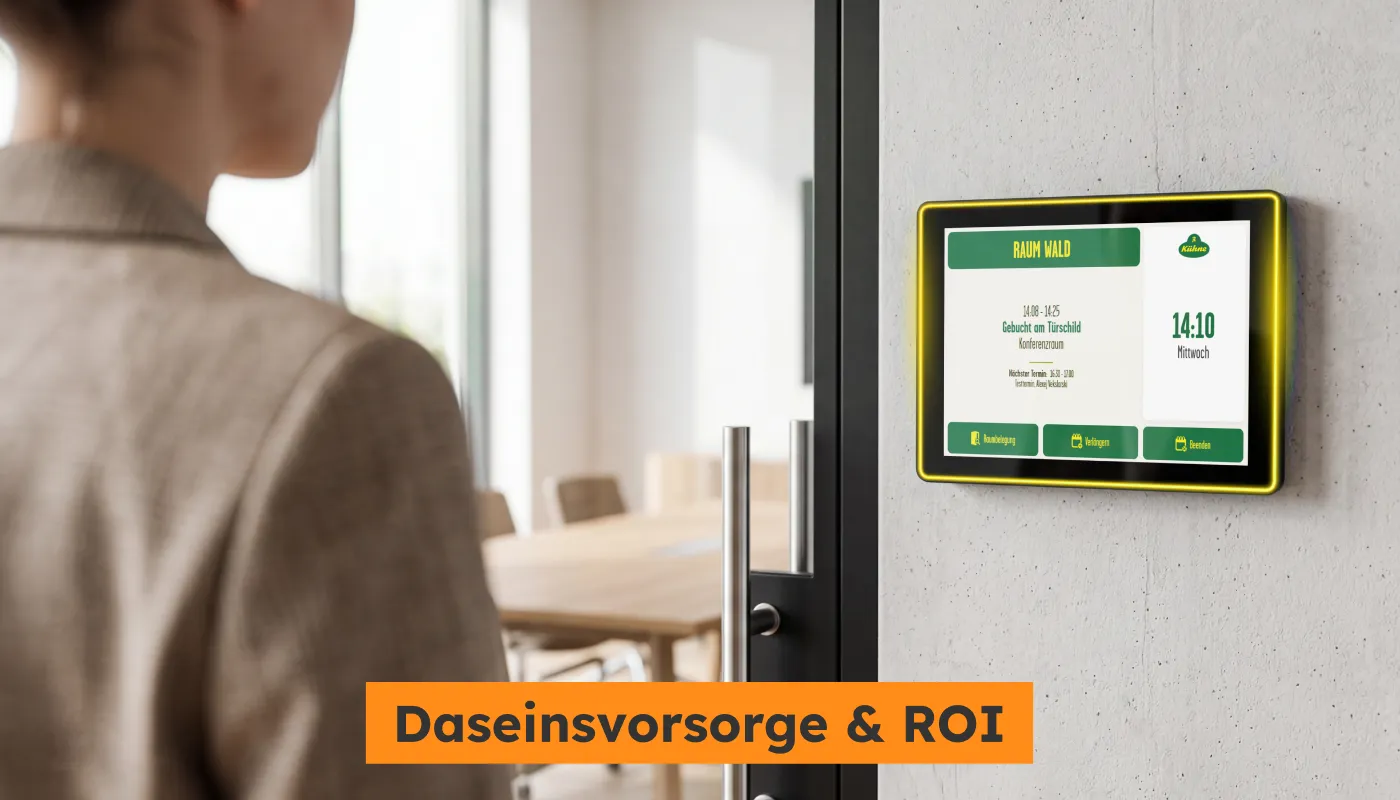 Ein digitales Türschild in den Farben von Kühne (Gelb/Grün) an einer Wand
